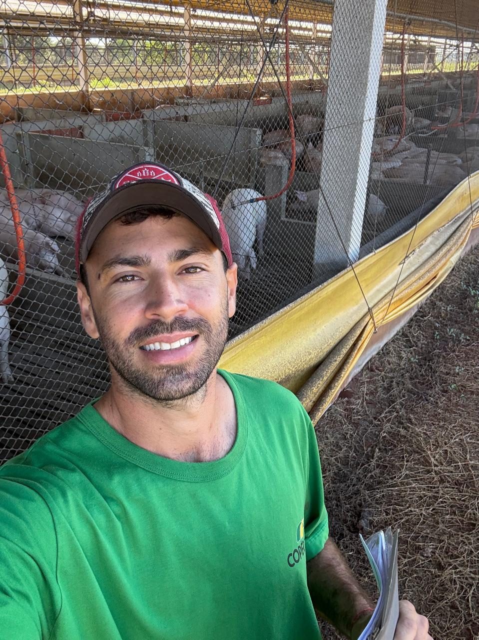 Dr. José Bernardino sorrindo em frente a uma granja de suínos
